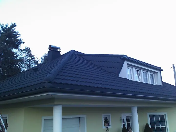 Štirikapna streha s temno kritino in frčado